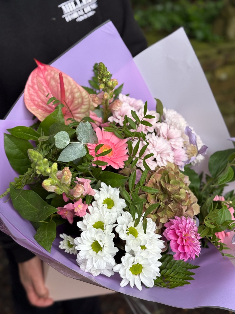 Blush and lilac hand-tied bouquet with pink anthurium, hydrangea, germini, chrysanthemums and seasonal foliage