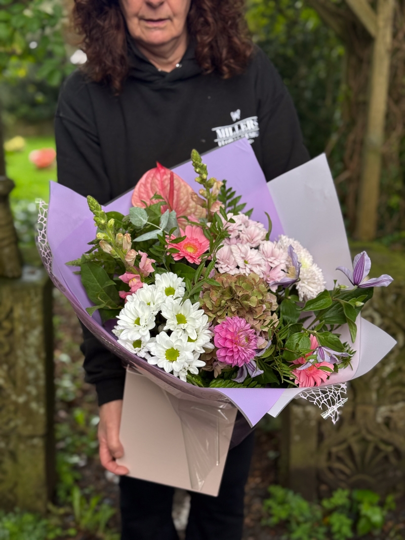 Blush and lilac hand-tied bouquet with pink anthurium, hydrangea, germini, chrysanthemums and seasonal foliage