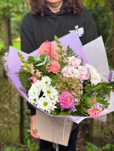 Blush and lilac hand-tied bouquet with pink anthurium, hydrangea, germini, chrysanthemums and seasonal foliage