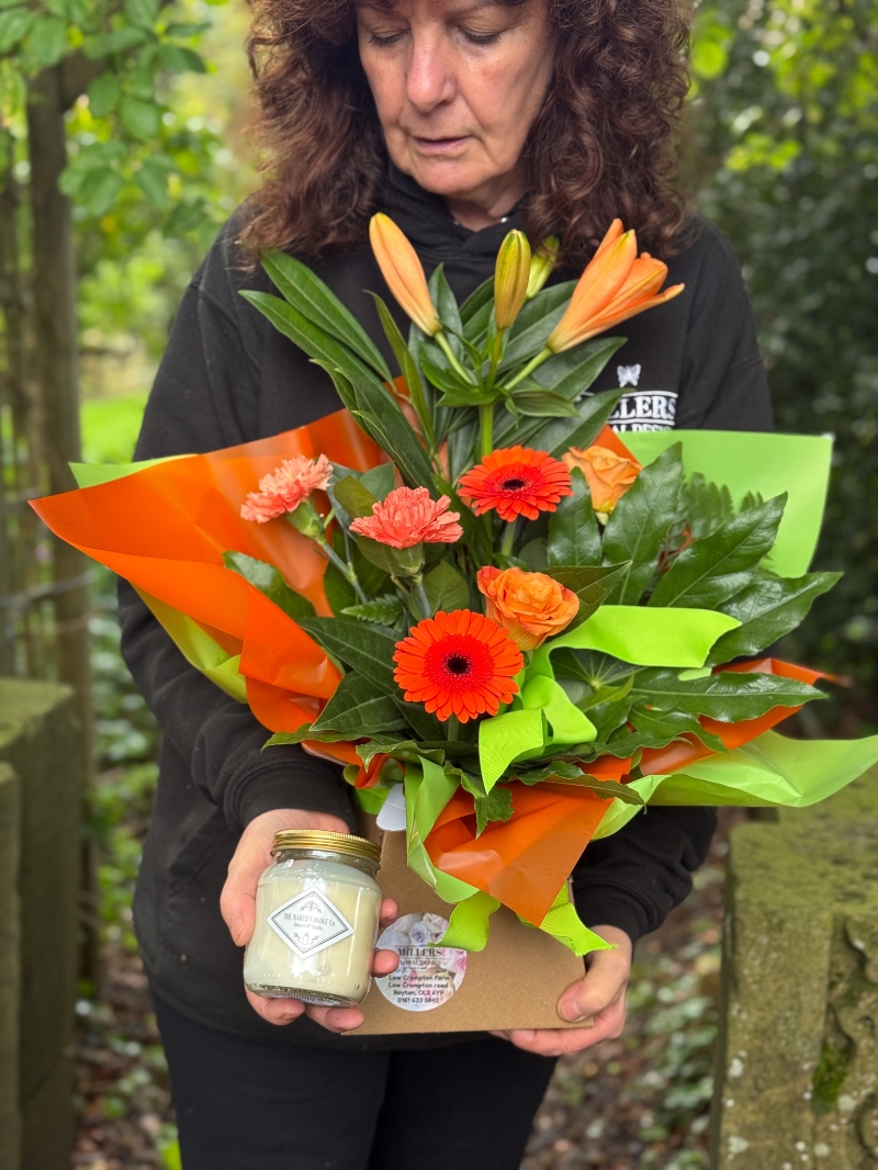 Petite bright flower gift box with orange lilies, germini, roses, carnations and fresh green foliage