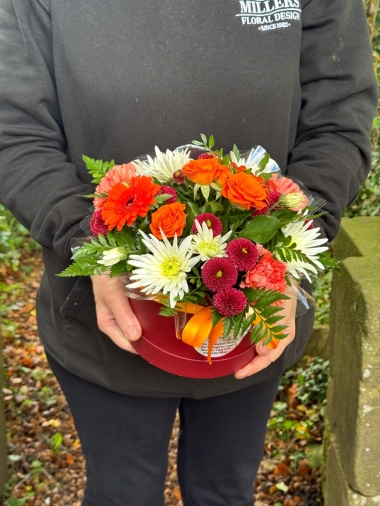 Autumn Glow orange and burgundy hatbox flower arrangement by Millers Floral Design in Royton