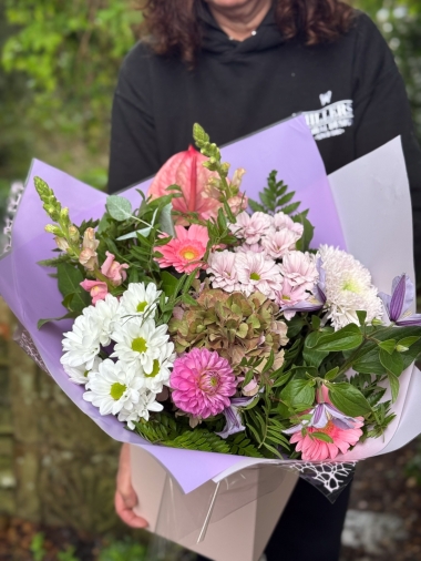 Blush and lilac hand-tied bouquet with pink anthurium, hydrangea, germini, chrysanthemums and seasonal foliage