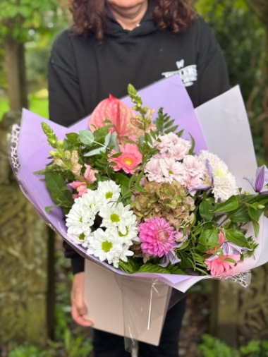 Blush and lilac hand-tied bouquet with pink anthurium, hydrangea, germini, chrysanthemums and seasonal foliage